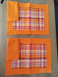 Due tovagliette con tovagliolo arancioni