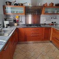 Cucina con top in pietra naturale spazzolata.