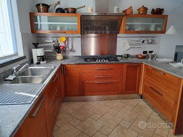 Cucina con top in pietra naturale spazzolata.