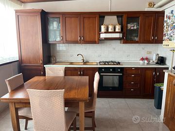 cucina in legno con tavoli e sedie abbinati