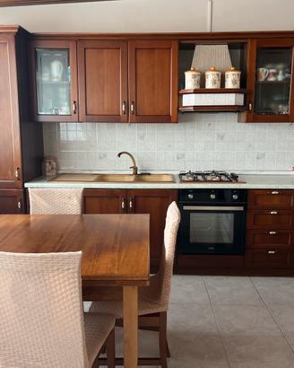 cucina in legno con tavoli e sedie abbinati