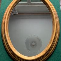 Specchio ovale vintage in resina dorata.