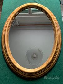 Specchio ovale vintage in resina dorata.