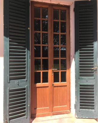 Porta a due ante a vetri in legno massello