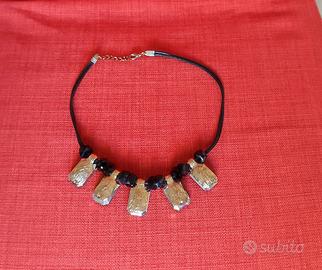 Collana con ciondoli neri e dorati.