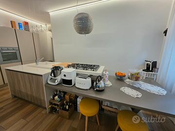 Cucina con isola in okite ed elettrodomestici.