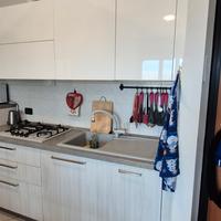 Cucina lineare, parete attrezzata tv e zona divano