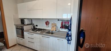 Cucina lineare, parete attrezzata tv e zona divano