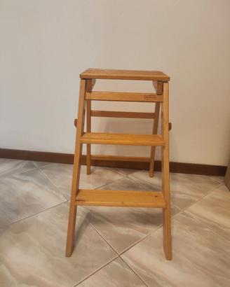 Sgabello pieghevole in legno con tre gradini.