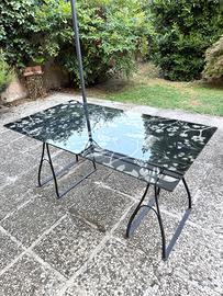 Tavolo a cavalletti con piano in vetro.