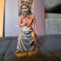 Nonna con capretto e pani nel grembiule. Legno 