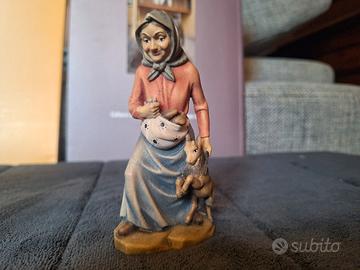 Nonna con capretto e pani nel grembiule. Legno 