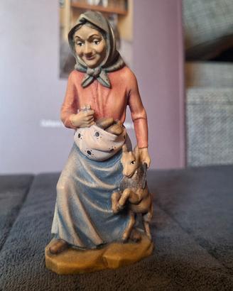 Nonna con capretto e pani nel grembiule. Legno 