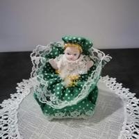 Bambolina in porcellana su poltroncina verde