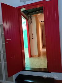 porta in legno massiccio rossa e altre porte verdi