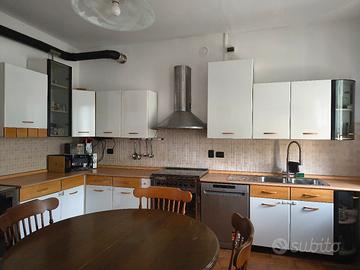 Cucina angolare con tavolo e sedie + stufa a legna