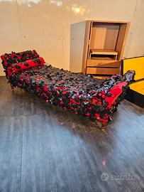 Divano lettino in tessuto rosso.