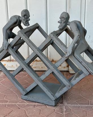 Portabottiglie in legno con figure decorative.