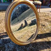 specchio ovale con cornice in legno dorata