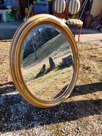 specchio ovale con cornice in legno dorata