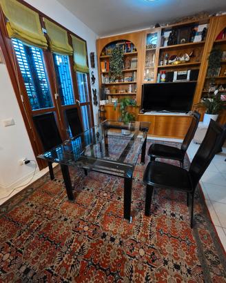 tavolo in cristallo e legno con sedie di pelle 