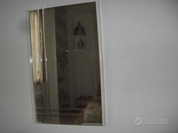 Specchio con cornice laterale e scanalature.