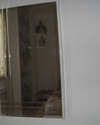 Specchio con cornice laterale e scanalature.