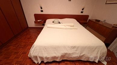 Letto matrimoniale con due comodini e un comò