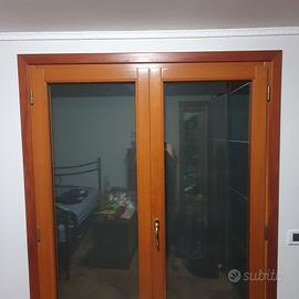 porta-finestra in legno a due ante con telaio