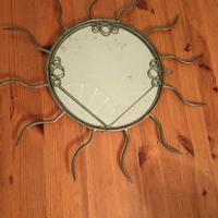 Specchio con cornice a raggiera. Metallo e vetro