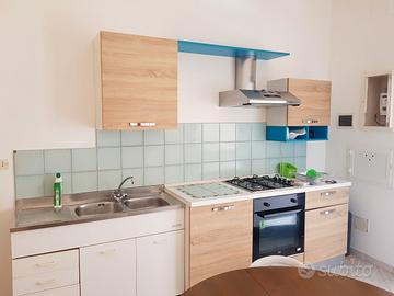 cucina con piano cottura cappa  forno lavandino in