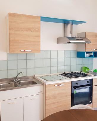 cucina con piano cottura cappa  forno lavandino in