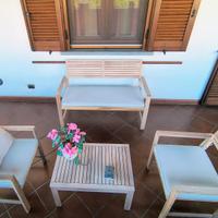 Tavolino in legno, divanetto, poltroncine.