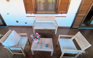 Tavolino in legno, divanetto, poltroncine.