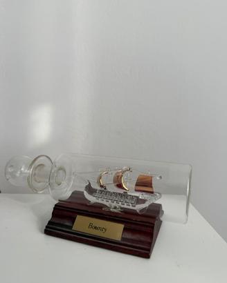 Nave Bounty in bottiglia in vetro con piedistallo
