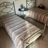 Letti compresi di rete e tavolo in ferro battuto.