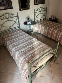 Letti compresi di rete e tavolo in ferro battuto.