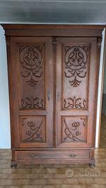 Armadio antico in legno con intagli decorativi