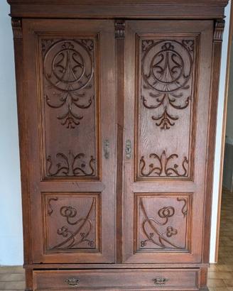 Armadio antico in legno con intagli decorativi