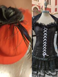 Vestito nero, coprispalle e cappellino rosso