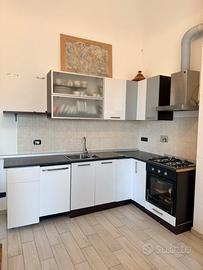 Cucina angolare con elettrodomestici e lavandino