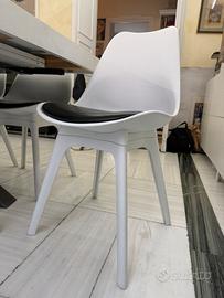 Sedie bianche con seduta nera.