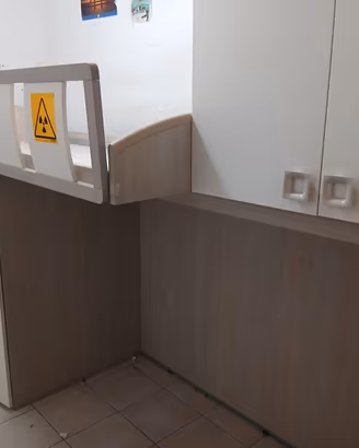 Cameretta con letto sopraelevato.