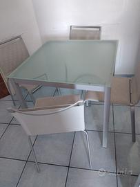 Tavolo in acciaio e cristallo e sedie