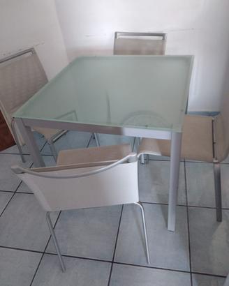 Tavolo in acciaio e cristallo e sedie