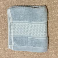 Asciugamano nuovo in spugna grigio chiaro