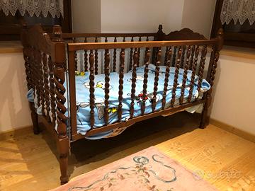 Lettino in legno di noce con materasso e lenzuola