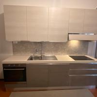 Cucina a parete con isola a muro e sgabelli