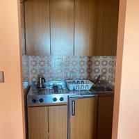 Cucina con frigo e fornelli