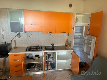 Cucina con elettrodomestici e divano letto